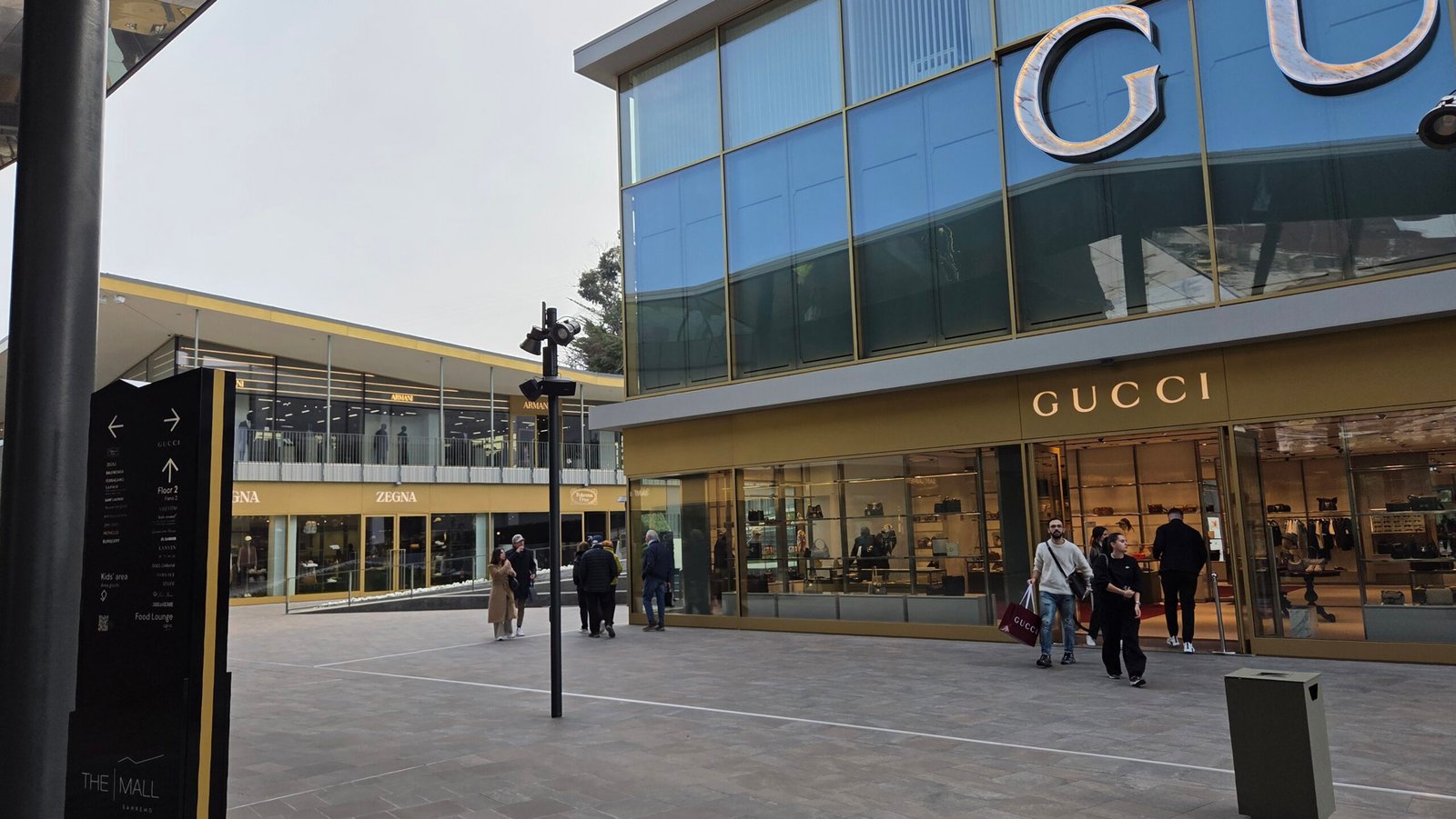 Exterior of The Mall Sanremo outlet complex with the Gucci storefront and Armani, Zegna signage
