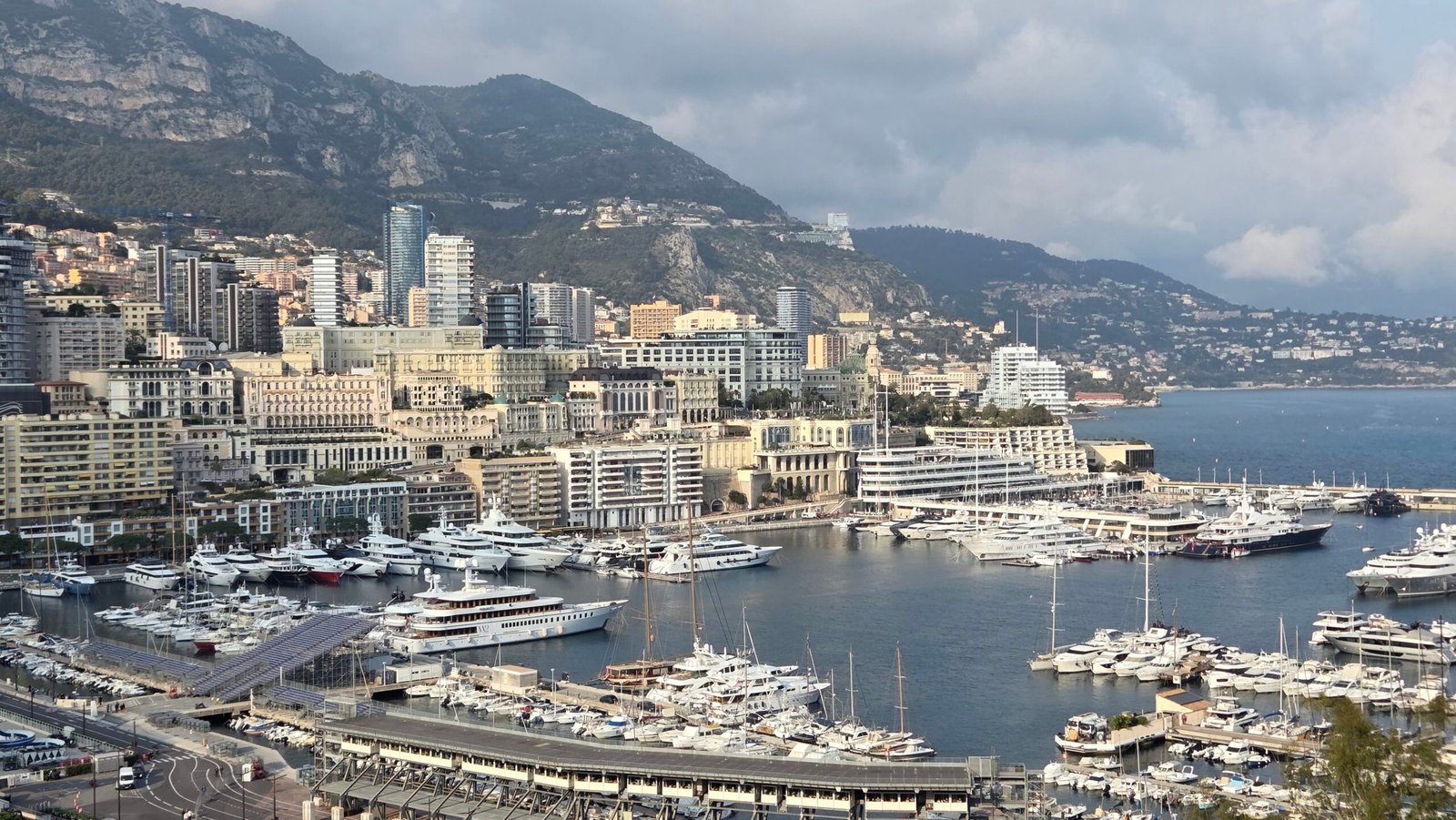 Monaco's skyline and Port Hercule harbor under a cloudy sky