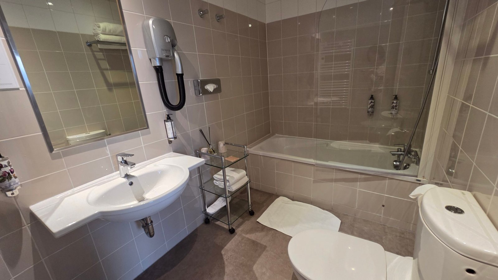 Spacious tiled bathroom with a bathtub in a Superior room at Hotel Suisse Nice