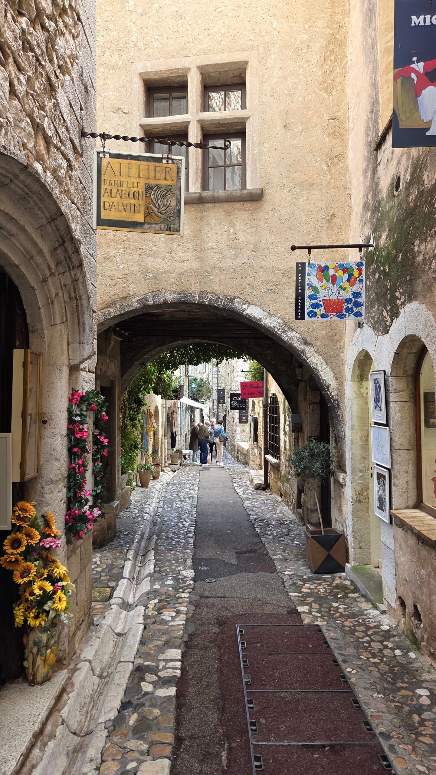 Narrow medieval stone alley lined with art galleries in Saint-Paul-de-Vence