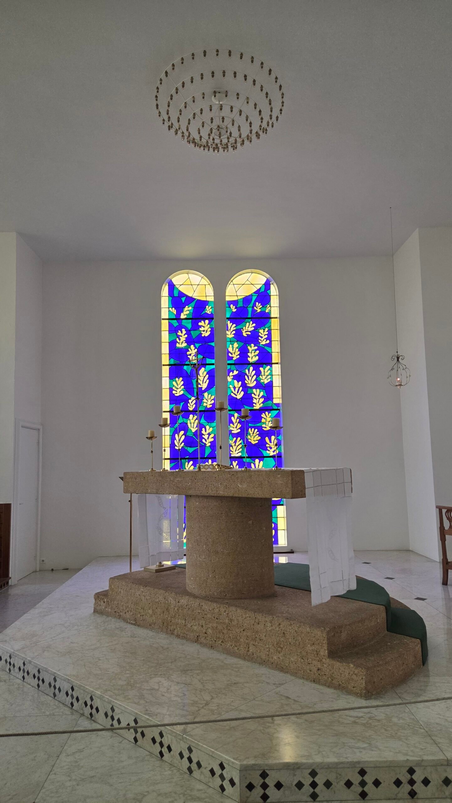 Blue and yellow stained glass windows above the altar at La Chapelle du Rosaire, Vence, designed by Matisse