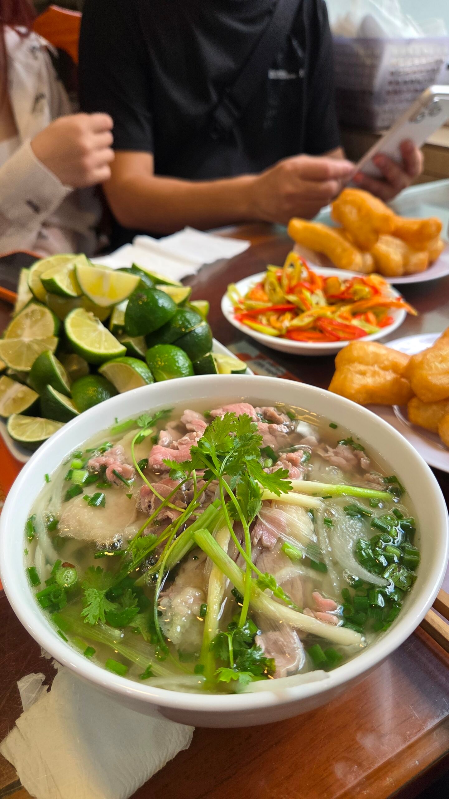 A bowl of beef phở topped with cilantro and scallions