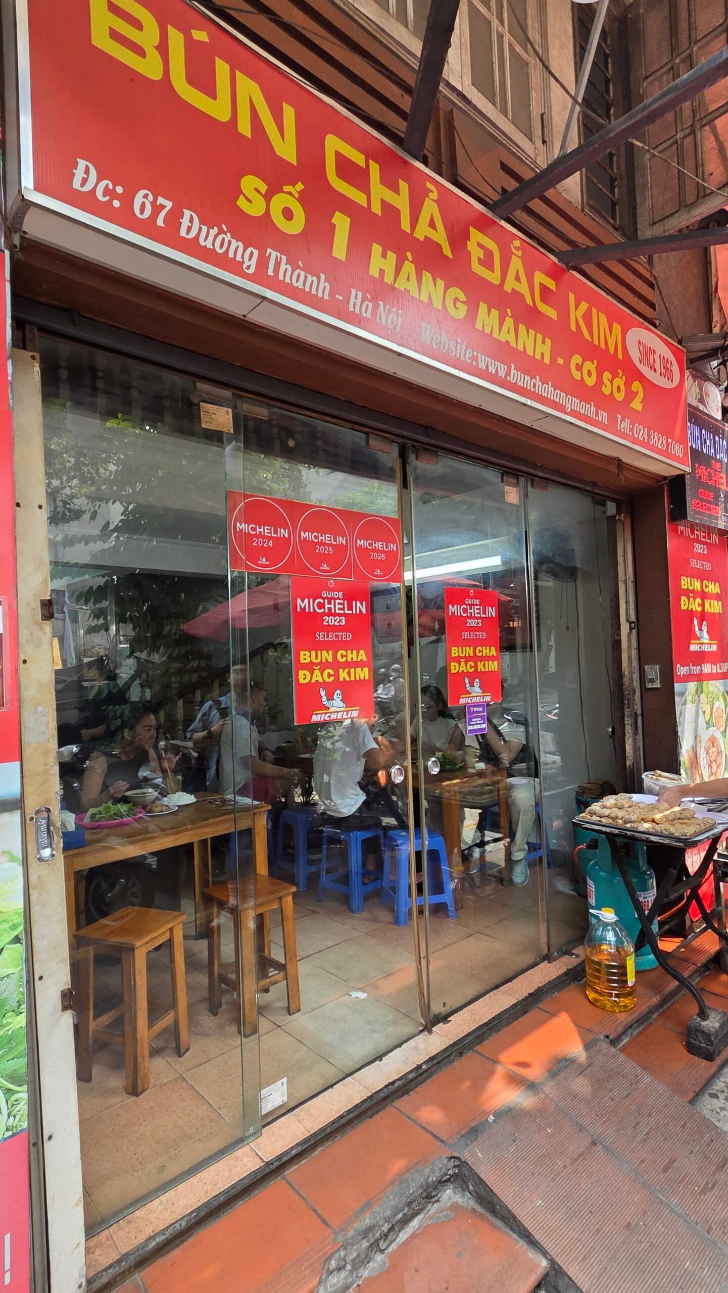 Bún Chả Đắc Kim's entrance, Michelin stickers on the glass door