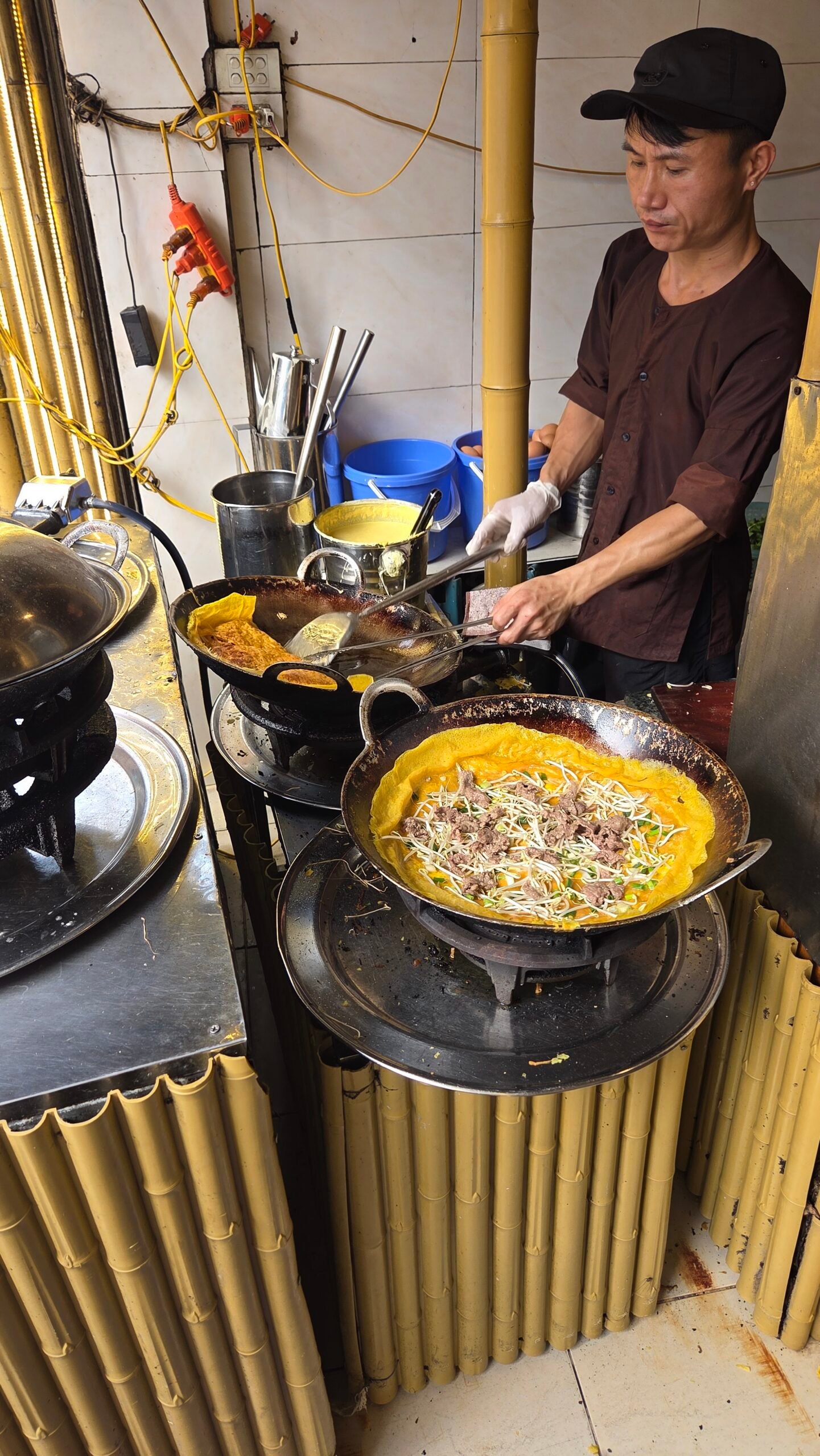 Bánh xèo being cooked in a large wok