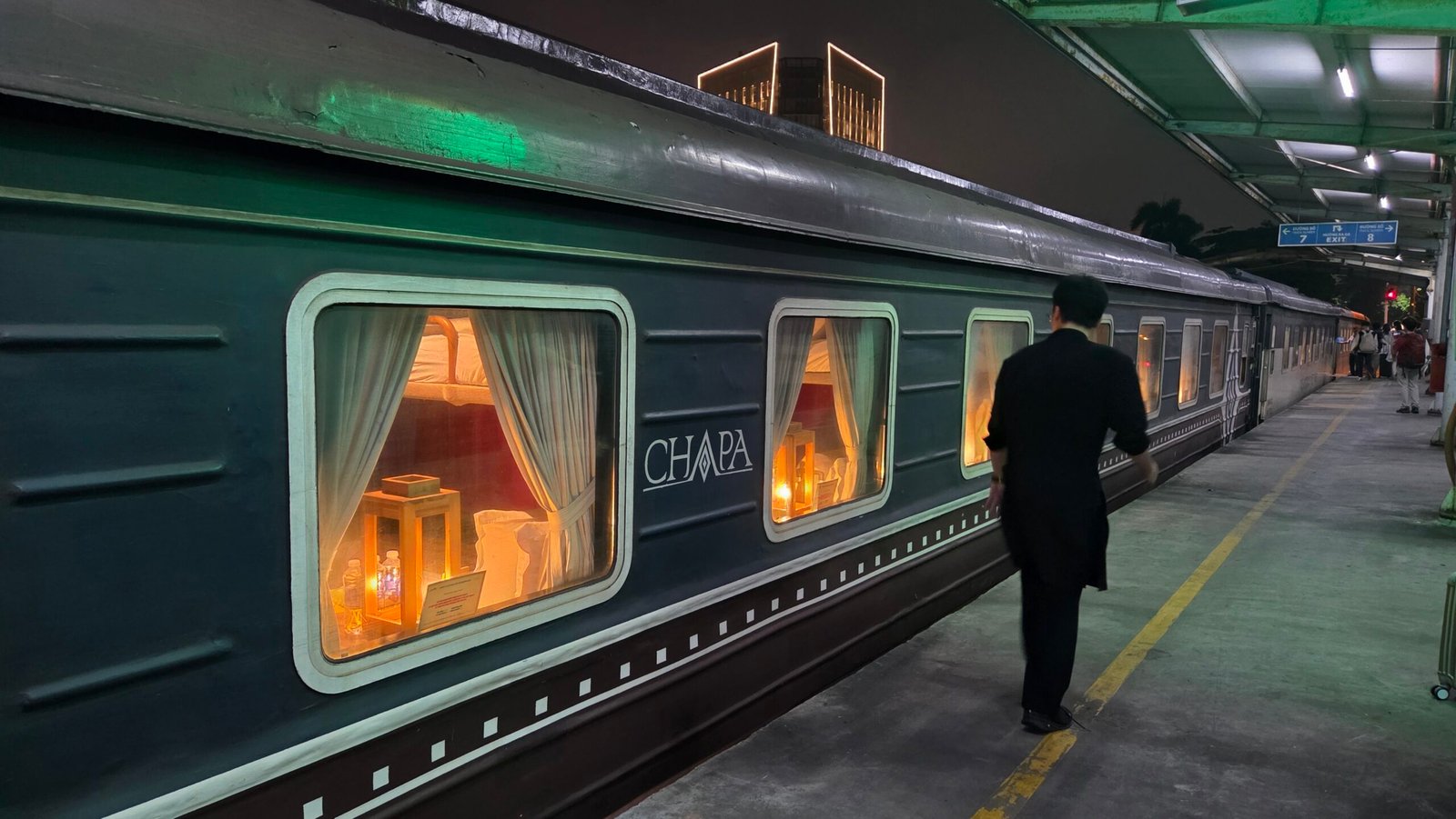 The Hanoi to Sapa sleeper train seen from the platform, cabin windows lit up in the dark
