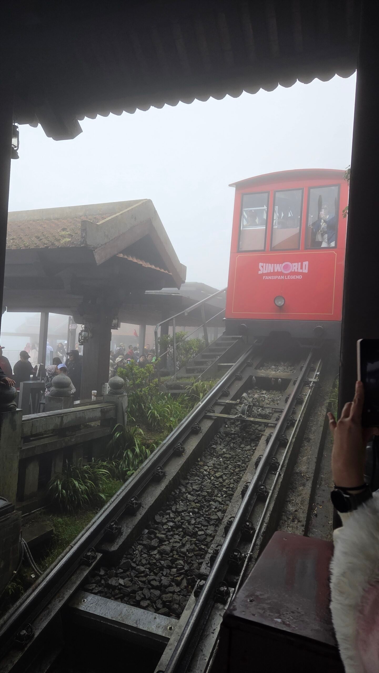 Red Peak Rail car pulling into the Fansipan summit platform in the fog
